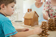 © Austockphoto - Young boy putting baubles on a gingerbread Christmas tree made of stars