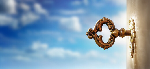 Fototapete - An old key in a keyhole on the background of an sky, macro photography. Retro style. The key to knowledge. Concept and idea for history, education, business, security, secret background.