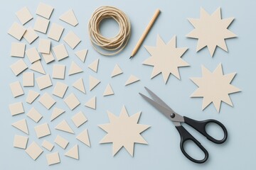 Poster - DIY paper craft project with cut shapes, pencil, scissors, and string on light blue background. Creative hobby concept flat lay style scene.