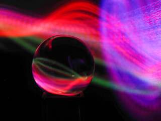 Wall Mural - a clear glass ball is sitting on a pedestal. colorful background. abstract graphic background. light