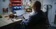 © Framestock - Employee Checking Real-Time Stocks and Exchange Market Charts Using Digital Tablet and Laptop. Man Making Cryptocurrency Investments During Working Hours in Workshop, Combining Job with Online Trading