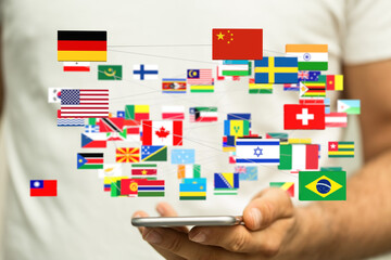 Leinwandbilder - Person holding phone displaying interconnected flags. Global network, international communication, world map concept.