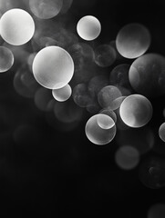 Poster - An abstract black and white image features a collection of translucent, overlapping bubbles of varying sizes. The bubbles are scattered across a dark background, creating a sense of depth and movement