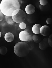 Poster - An abstract black and white image features a collection of translucent, overlapping bubbles of varying sizes. The bubbles are scattered across a dark background, creating a sense of depth and movement