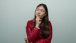 © Krakenimages.com - Woman pondering thoughtfully against a white background, wearing a red jacket with long dark hair, showcasing contemplation and expression