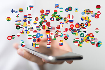 Fototapete - Person holding phone with flags of many countries. Global communication, international business concept.