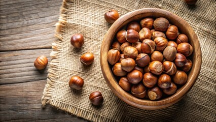 Aufkleber - A wooden bowl filled with whole hazelnuts, scattered on a burlap cloth over a wooden table