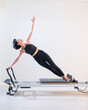 © Михаил Решетников - Asian woman doing pilates on reformer.