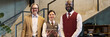 © pressmaster - Portrait of three smiling hotel staff members standing together in hotel lobby, emphasizing teamwork and professionalism, including senior Caucasian and Black person in professional attire