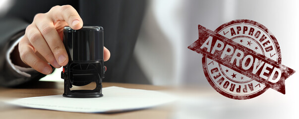 Fototapete - Man stamping document at desk and stamp with word Approved. Banner design