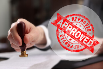 Fototapete - Man stamping document at table and red stamp Approved