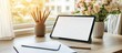 © MKS - The home office setup includes a sunlit desk, flowers, a notebook, and a tablet