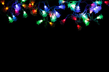 Poster - Christmas lights frame on black background. Holiday shiny garland border with copy space, top view. Xmas tree decorations, winter holidays illumination