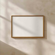 © cefwr - realistic mockup of an empty 32 horizontal picture frame hanging on a light beige wall frame is in landscape orientation thin vintage brass or antique gold m