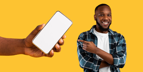 Poster - Recommendation. Portrait of cheerful black guy pointing finger at big blank cell phone screen, hand holding device with white empty display. Gadget with free space for mock up, banner panorama