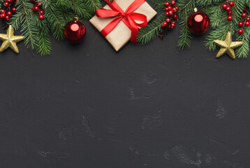 Aufkleber - Traditional Christmas ornament. Green fir with red balls, golden stars and gift box on black background, top view, copy space