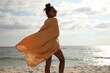 © New Africa - Beautiful African American woman with beach towel on seashore