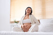 © Pixel-Shot - Young pregnant woman sitting in bedroom