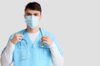 © Pixel-Shot - Male doctor in medical mask with stethoscope on light background