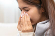 © Pormezz - flu in winter season concept, Asian young woman sneezing and running nose from flu