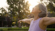 © ChayTee - Asia adult aged people middle age mindful happy old woman open arm yoga deep calm stress relief outdoor nature public park sun light self love relax elder aging life asian female mental health care.