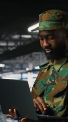 Poster - Vertical video Army technician in command center server room using laptop to install and maintain IT systems. Military data center admin overseeing computer networks and information systems, camera B
