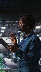 Poster - Vertical video Server room admin using tablet and headset microphone to provide infrastructure tech support. Data center IT specialist resolves backend issues while coordinating with remote teams