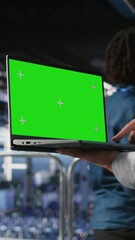 Poster - vertical video close up of server room worker using green screen laptop next to colleague reviewing 