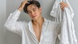© misster - Young man with stylish hairstyle posing confidently in relaxed home setting with white clothing