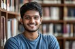 © banrak - Portrait of Indian student smiling softly, in a calm library, window light from the left side
