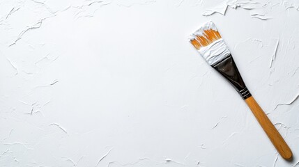 Aufkleber - A brush covered in white paint rests on a textured canvas, symbolizing creativity and the beauty of artistic expression captured in a simple yet profound manner.