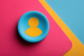 Aufkleber - Vibrant image featuring yellow user icon on blue circular background, set against colorful backdrop of pink, yellow, and blue geometric shapes. composition is artistic and modern