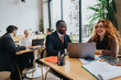 © qunica.com - Colleagues engaging in a productive business discussion at a co-working center with natural surroundings, highlighting teamwork, professional network building, and innovative work environments.