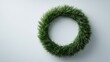 © kiimoshi - A vibrant green wreath made of artificial grass, set against a minimalistic background. This decorative piece adds a touch of nature-inspired charm to any space.