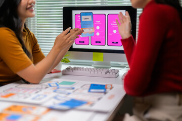 two ui/ux web designers discussing about the user interface of a mobile application they're developi
