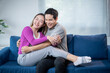 © Apichat - A man and a woman are sitting on a blue couch