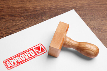 Fototapete - Sheet of paper with red stamp Approved and wooden stamp on table