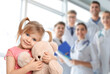 © New Africa - Cute child holding toy bear and medical staff in hospital. Pediatric ward
