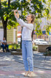 © Andrii Iemelianenko - Young woman tourist trying to catch a communication signal and Internet on mobile phone, raised the phone up for a better connection in city street. Frustrated Caucasian teenager girl in city town.