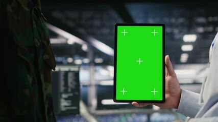 Poster - Military technicians in data center use green screen mockup tablet to monitor systems. Army operators in server room ensuring stable infrastructure using chroma key device, camera B