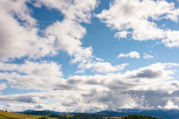 Wall Mural - heavy clouds on a blue sky above mountains september. dramatic view. early autumn cloudy weather over carpathian range. dynamic formation
