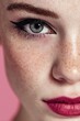 © Blackmint Studio - A young woman displays her artistic makeup, featuring bold colors and striking eyeliner, highlighting her beautiful features against a soft pink background. Her freckles add charm to her look