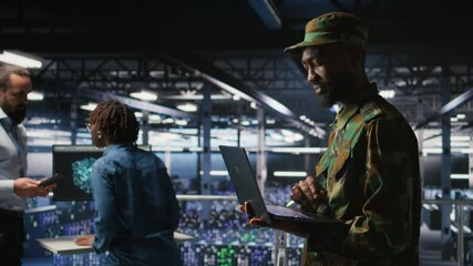 Poster - Army IT specialist in data center using laptop to defend networks against cyber threats. Military command center admin using notebook to identify potential intrusions or malicious activities, camera A