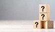 © Innovative - wooden blocks with question marks on them on white background