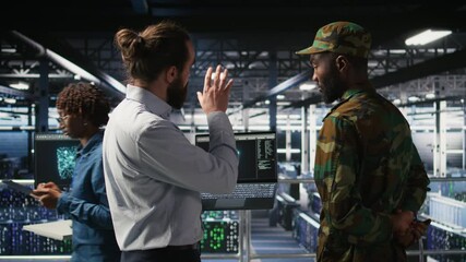Poster - Military personnel overseeing AI computing operations on laptop in high tech server facility. Army tech experts using artificial intelligence to oversee communication systems, camera A