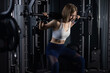 © littlepigpower - Women exercising together lifting weights in a gym on a dark background