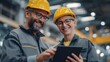 © Jittapon - Two industry workers wearing safety helmets and glasses working together with a tablet device in a modern manufacturing facility demonstrating teamwork and the use of technology in the workplace