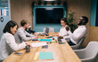 © BullRun - Energetic multicultural team celebrating success in creative office, laughing and enjoying moment together during productive project discussion around wooden conference table with laptops and charts