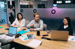 © BullRun - Young diverse coworkers having serious conversation during business meeting in modern office, analyzing reports and brainstorming ideas around large wooden table with laptops and documents