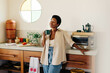 © (JLco) Julia Amaral - Brazilian woman enjoying coffee and a relaxing moment in the kitchen